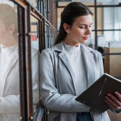 attractive-young-businesswoman-reading-diary-office_23-2148187207